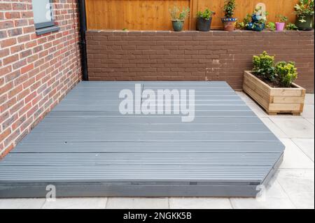 Neu erbaute und bemalte graue Holzterrasse im hinteren Garten. Stockfoto