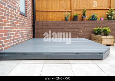Neu erbaute und bemalte graue Holzterrasse im hinteren Garten. Stockfoto