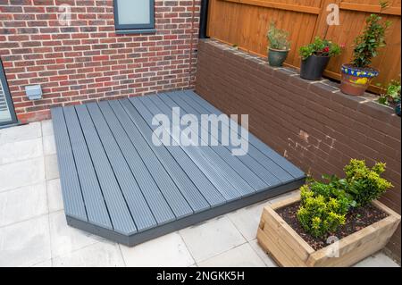 Neu erbaute und bemalte graue Holzterrasse im hinteren Garten. Stockfoto