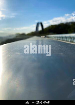 Die Struktur des Metallgeländers aus nächster Nähe. Nahaufnahme Stahlgeländer an der Granitfliesenwand. Stockfoto