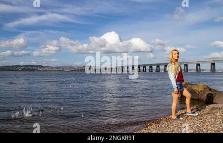 An einem wunderschönen Oktobertag in Wormit Beach, Fife, wirft Rhianna Martin Kiesel über ihren Kopf in den Fluss Tay, Schottland Stockfoto