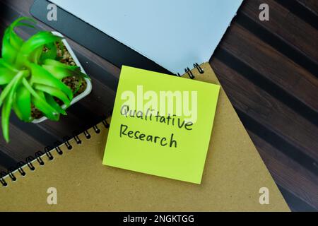 Konzept der qualitativen Forschung Schreiben auf Haftnotizen isoliert auf Holztisch. Stockfoto