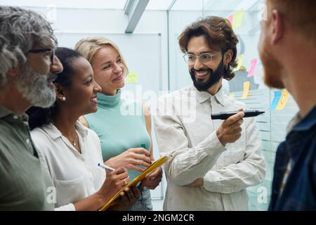 Kreative Kollegen im Büro treffen. Verschiedene Arbeiter aus dem Team von Geschäftsleuten, die stehen Stockfoto