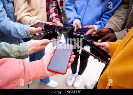 Personen, die ihre Handys mit einem dunklen Bildschirm vor der Kamera zeigen. Suchtbegriff und soziale Vernetzung. Stockfoto