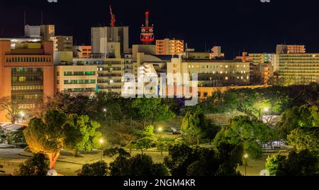 Lichter von mittelhohen Büro- und Wohngebäuden in einer Kleinstadt bei Nacht Stockfoto