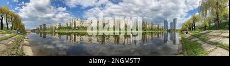 Panorama der Stadt über dem Fluss. Wunderschöner Sommerblick auf die Standardbauten der Insel Rusanovsky. Fischer am Kanalufer. Kiew Ukraine 202 Stockfoto