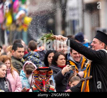 Elhovo Bulgarien Februar 18 2023: Kochgruppen und der "Djamalo", ein Brauch aus dem Dorf Malomirovo. Kuker-Rituale symbolisieren das Ende des Winters und die Ankunft des Frühlings. Heute führten Teams aus der ganzen Region rituelle Aktionen von Kukers Memebers durch, wie Pflügen, Ernten, Aussaat, Hochzeit für Gesundheit und Fruchtbarkeit. Sie setzen gruselige Masken auf ihren Kopf, hängen Klapper, Glocken und Stöcke auf und wollen böse Geister und unsaubere Kräfte vertreiben. Cliff Norton Alamy Live News Stockfoto