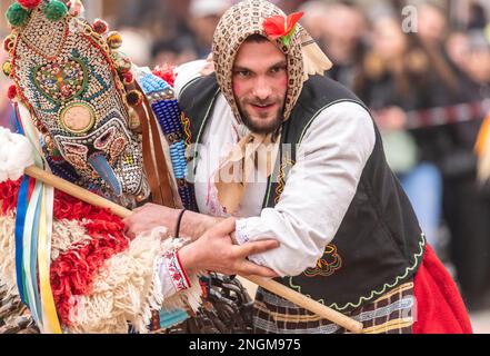 Elhovo Bulgarien Februar 18 2023: Kochgruppen und der "Djamalo", ein Brauch aus dem Dorf Malomirovo. Kuker-Rituale symbolisieren das Ende des Winters und die Ankunft des Frühlings. Heute führten Teams aus der ganzen Region rituelle Aktionen von Kukers Memebers durch, wie Pflügen, Ernten, Aussaat, Hochzeit für Gesundheit und Fruchtbarkeit. Sie setzen gruselige Masken auf ihren Kopf, hängen Klapper, Glocken und Stöcke auf und wollen böse Geister und unsaubere Kräfte vertreiben. Cliff Norton Alamy Live News Stockfoto