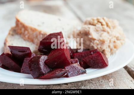 Brotscheiben mit Brotaufstrich Walnuss, Knoblauch und Kartoffeln serviert mit gerösteten Rüben. Stockfoto