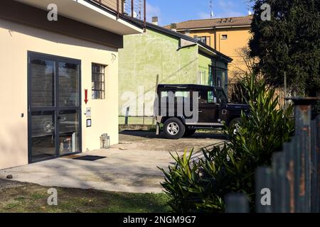 Der schwarze Land Rover Defender parkte an einem sonnigen Tag in einem Garten Stockfoto