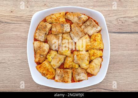 Gebackene Stücke Fischfilet auf Karottensalat auf dem Tisch, Draufsicht. Stockfoto