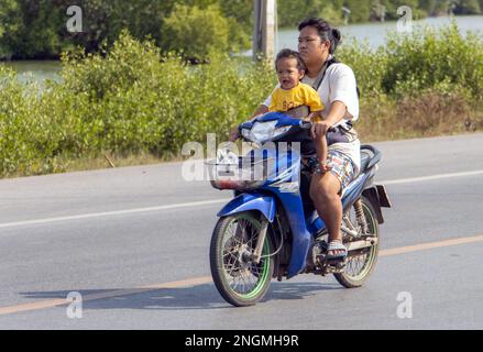 BANGKOK, THAILAND, FEBRUAR 07 2023, Eine Frau fährt weinendes Baby auf einem Motorrad Stockfoto