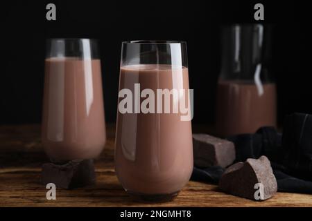 Köstliche Schokoladenmilch in Gläsern auf einem Holztisch Stockfoto