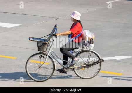 Eine Lotterieverkäuferin fährt Fahrrad, Thailand Stockfoto