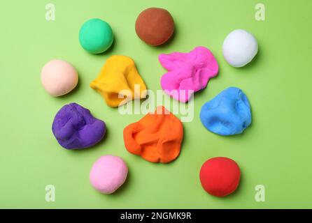 Buntes Plastikin auf grünem Hintergrund, flach liegend Stockfoto