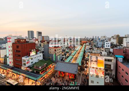 Tokio, den beliebten Schrein und Sensoji-Tempel in Asakusa. Beleuchtete Nakamise Shopping Straße, die von der Pforte des Tempels, und Tokio Skyline. Negativer Platz Stockfoto