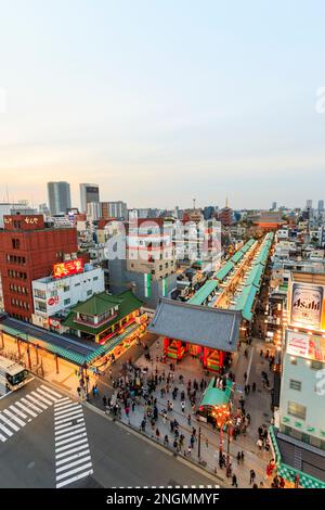 Tokio, den beliebten Schrein und Sensoji-Tempel in Asakusa. Beleuchtete Nakamise Shopping Straße, die von der Pforte des Tempels, und Tokio Skyline. Negativer Platz Stockfoto