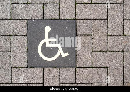 Piktogramm Behindertenparkplatz auf Pflastersteinen Stockfoto