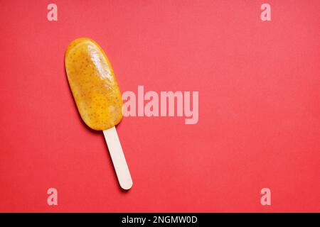 Passionsfrucht oder Maracuja popsicle oder Eis am Stiel oder Eis pop auf rotem Hintergrund mit Kopie Raum Stockfoto