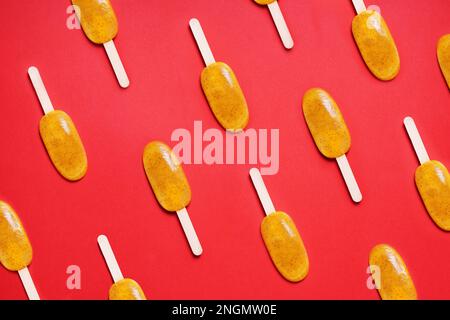 Ansicht von oben Passionsfrucht popsicle oder Eis am Stiel oder Eis pops flach Muster auf roten Hintergrund Stockfoto