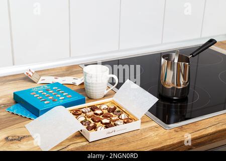 Zürich, Schweiz - Januar 7 2023: Lindt Mini Pralines Box. Öffnen Sie eine kleine Geschenkbox mit Süßigkeiten aus Schweizer Schokolade, die in der Küche zum Kaffee bereit ist. Luxuriöse Auswahl an Milch, dunklen und weißen Süßigkeiten. Stockfoto