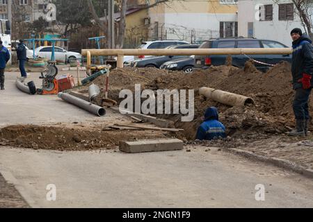 Tiraspol, Moldawien - 13, Februar 2023: Verlegung von sanitären Abwasserrohren. Herstellung von Abwasserrohren aus Kunststoff zur Verlegung. Abwasserdienstleister und Stockfoto