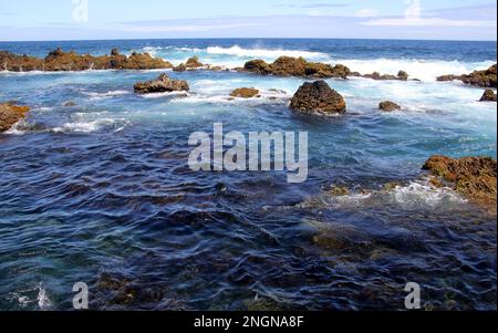 Vulkanische Lavafelsen in den Surfwellen der Küste von Biscoitos, Nordküste von Terceira, Azoren, Portugal Stockfoto