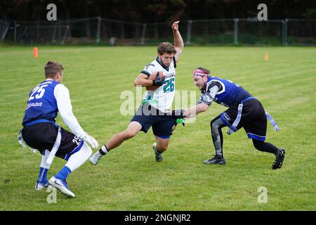 Luftduellen zwischen Oppositionsspielern während eines Flaggenfußballspiels in Wales. Stockfoto