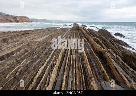 Blick auf steil geneigte Schichten von Flysch-geologischer Formation an der Atlantikküste bei Zumaia bei Ebbe, Baskenland, Spanien Stockfoto