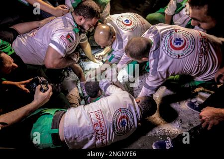 Gaza, Palästina. Rettungs- und Zivilverteidigungsteams suchen nach Überlebenden des israelischen Bombenanschlags auf eine Wohngegend in der Al Wahda Street. Stockfoto