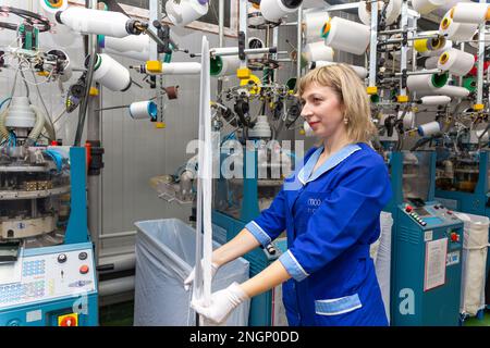 Grodno, Belarus - 22. November 2017: Eine Mitarbeiterin führt eine visuelle Qualitätskontrolle der Strumpfwaren im JLLC Conte Spa durch. Sogar hochpräzise Fertigung Stockfoto