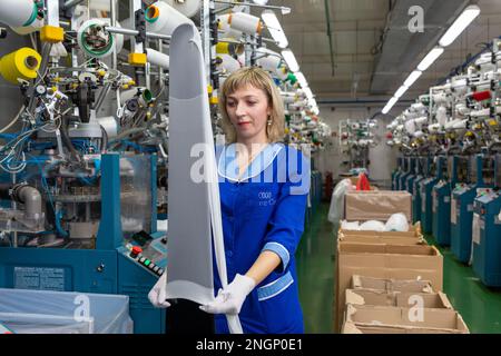 Grodno, Belarus - 22. November 2017: Eine Mitarbeiterin führt eine visuelle Qualitätskontrolle der Strumpfwaren im JLLC Conte Spa durch. Sogar hochpräzise Fertigung Stockfoto