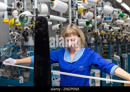 Grodno, Belarus - 22. November 2017: Eine Mitarbeiterin führt eine visuelle Qualitätskontrolle der Strumpfwaren im JLLC Conte Spa durch. Sogar hochpräzise Fertigung Stockfoto