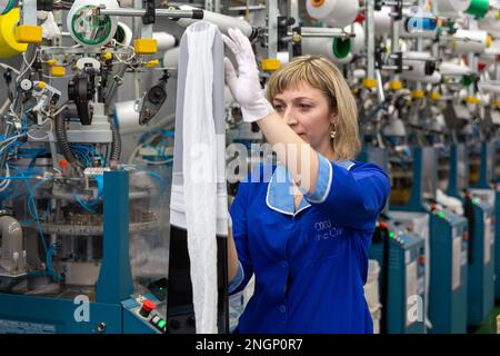 Grodno, Belarus - 22. November 2017: Eine Mitarbeiterin führt eine visuelle Qualitätskontrolle der Strumpfwaren im JLLC Conte Spa durch. Sogar hochpräzise Fertigung Stockfoto