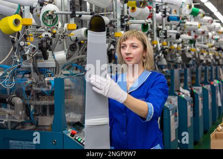 Grodno, Belarus - 22. November 2017: Eine Mitarbeiterin führt eine visuelle Qualitätskontrolle der Strumpfwaren im JLLC Conte Spa durch. Sogar hochpräzise Fertigung Stockfoto