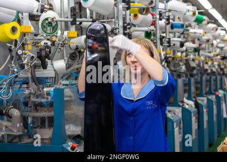 Grodno, Belarus - 22. November 2017: Eine Mitarbeiterin führt eine visuelle Qualitätskontrolle der Strumpfwaren im JLLC Conte Spa durch. Sogar hochpräzise Fertigung Stockfoto