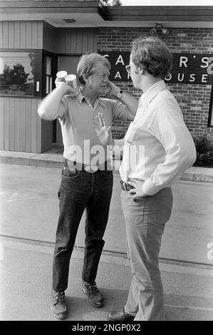 Präsident Jimmy Carter spricht mit dem stellvertretenden Pressesprecher des Weißen Hauses Rex Granum vor Carters Warehouse während eines Urlaubs in seiner Heimatstadt Plains, GA im Jahr 1977. Stockfoto