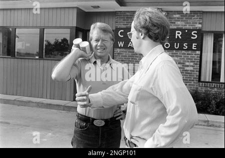 Präsident Jimmy Carter spricht mit dem stellvertretenden Pressesprecher des Weißen Hauses Rex Granum vor Carters Warehouse während eines Urlaubs in seiner Heimatstadt Plains, GA im Jahr 1977. Stockfoto