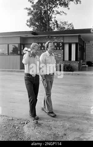 Präsident Jimmy Carter spricht mit dem stellvertretenden Pressesprecher des Weißen Hauses Rex Granum vor Carters Warehouse während eines Urlaubs in seiner Heimatstadt Plains, GA im Jahr 1977. Stockfoto