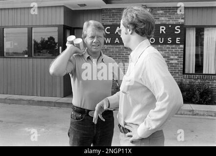 Präsident Jimmy Carter spricht mit dem stellvertretenden Pressesprecher des Weißen Hauses Rex Granum vor Carters Warehouse während eines Urlaubs in seiner Heimatstadt Plains, GA im Jahr 1977. Stockfoto