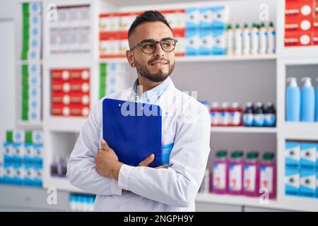 Junger hispanischer Apotheker mit Klemmbrett in der Apotheke Stockfoto