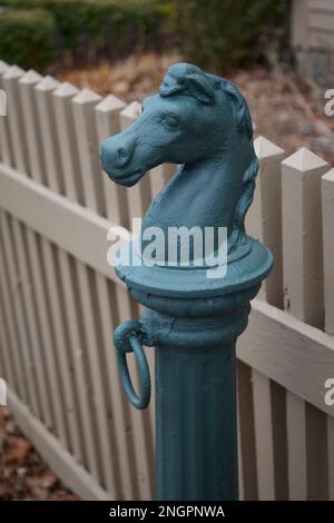 Metallischer, grüner Pferdeanhänger in Connecticut mit hellbraunem Holzzaun in der Nähe. Hier hätten Sie Ihr Pferd gefesselt, während Sie hier waren. Stockfoto