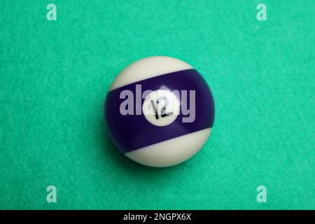 Billardkugel mit Nummer 12 auf grünem Tisch, Draufsicht Stockfoto