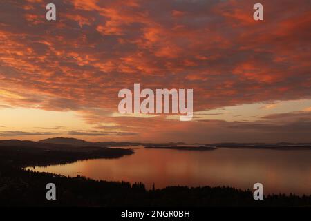 Ein dramatischer Sonnenuntergang mit rosa und blauen Wolken über der Cordova Bay. Vom Mount Douglas auf Vancouver Island, BC, Kanada. Stockfoto