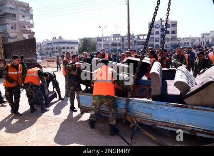 Hama, Syrien. 18. Februar 2023. Arbeiter transportieren Möbel aus einem Wohngebäude, das während des Erdbebens in Hama, Zentralsyrien, am 18. Februar 2023 beschädigt wurde. Kredit: Str/Xinhua/Alamy Live News Stockfoto