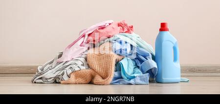 Schmutzige Kleidung auf dem Boden in der Nähe einer hellen Wand Stockfoto