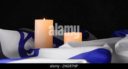 Brennende Kerzen und Flagge Israels auf dunklem Hintergrund Stockfoto