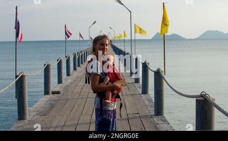 Tourist mit Baby an der Brust auf einem Ponton, das auf die Fähre wartet Stockfoto