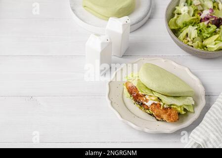 Das Brötchen ist grün, gedünstet, mit Gemüseblättern und Sesamsamen Stockfoto