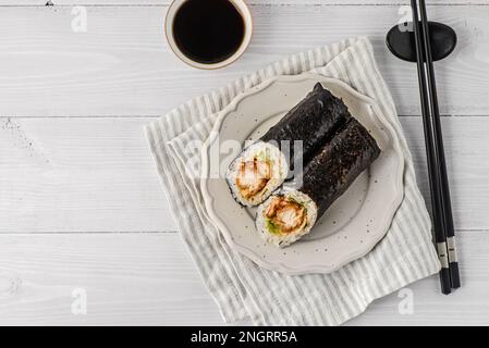 Gemüserollen in Nori-Algen. Neben Sojasoße und Sushi-Stäbchen Stockfoto